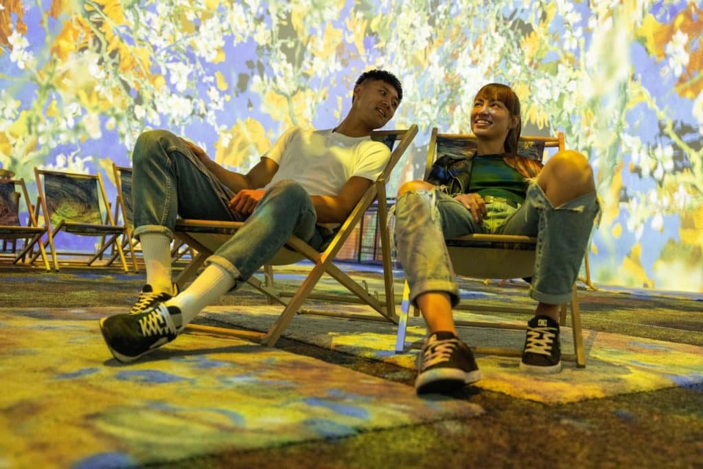 two friends sitting on deck chairs at the Van Gogh exhibition