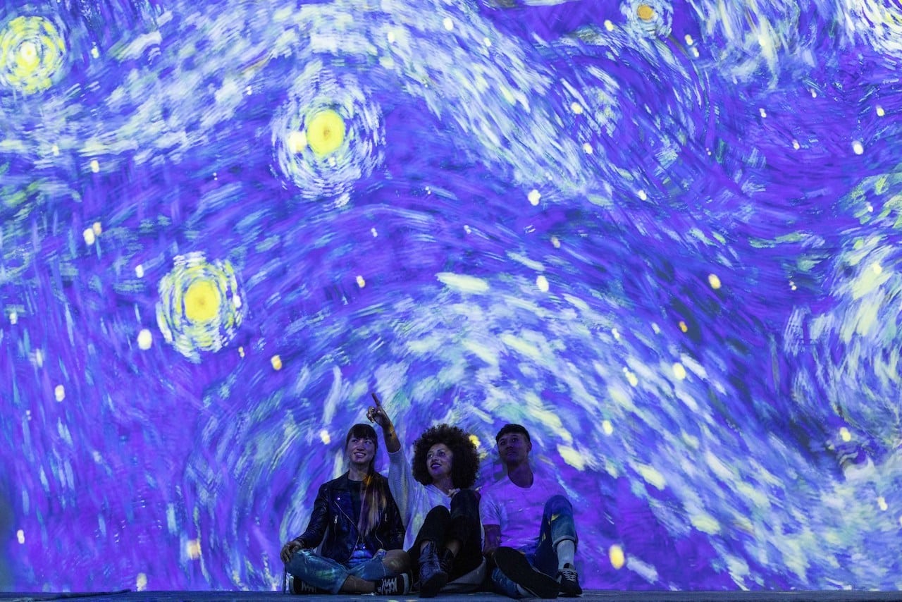 Three friends underneath the starry night at the Van Gogh exhibition