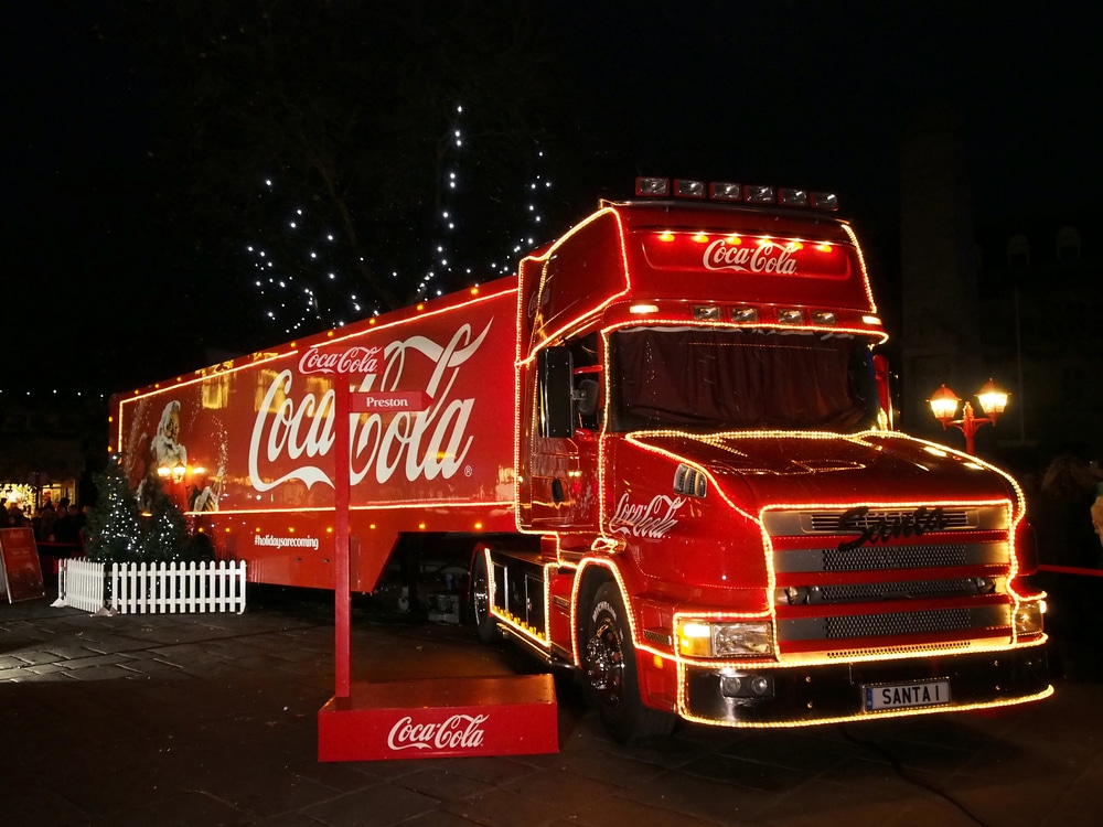 The bright red Coca-Cola Christmas truck, illuminated by fairylights.