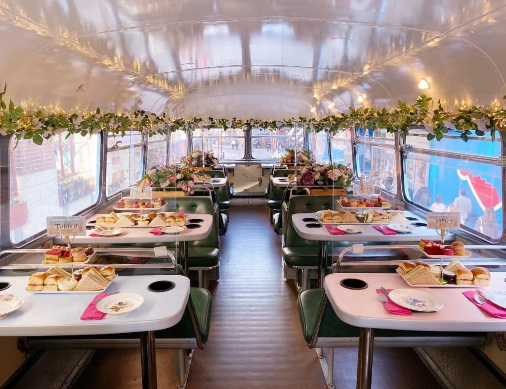 The top deck of an old Dublin bus, decked out with tables and afternoon tea.