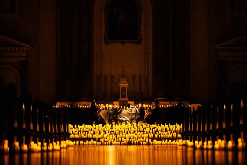 A string quartet play, surrounded by candles at St. Andrew's Church in Dublin.