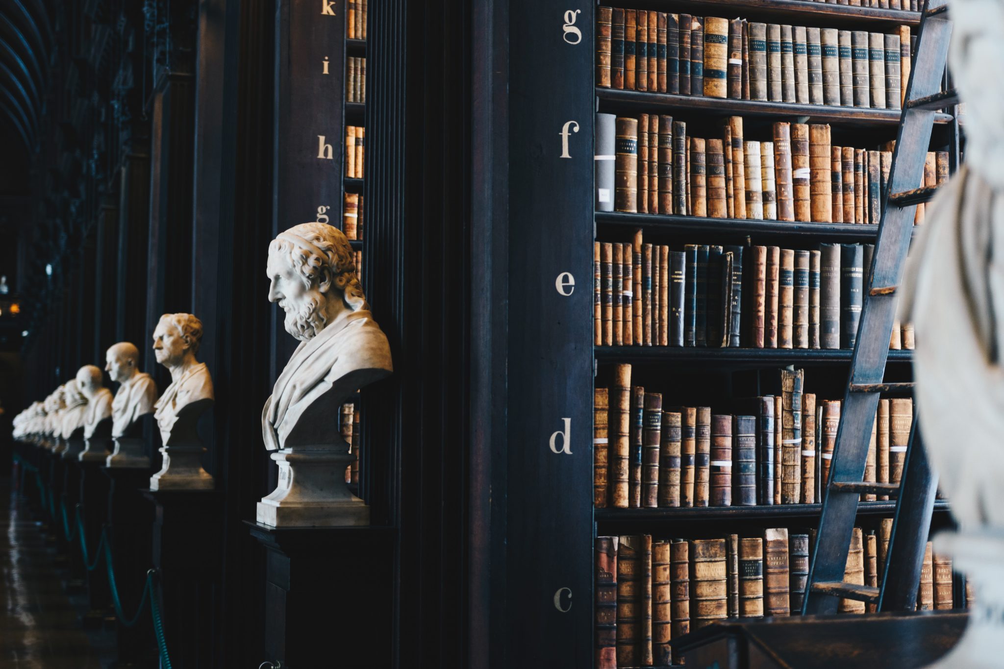 A close-up of a bust and bookshelves inside the Long Room at the Old Library in Trinity College Dublin. 