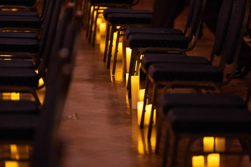 Rows of chairs surrounded by candles as a Candlelight Concert.