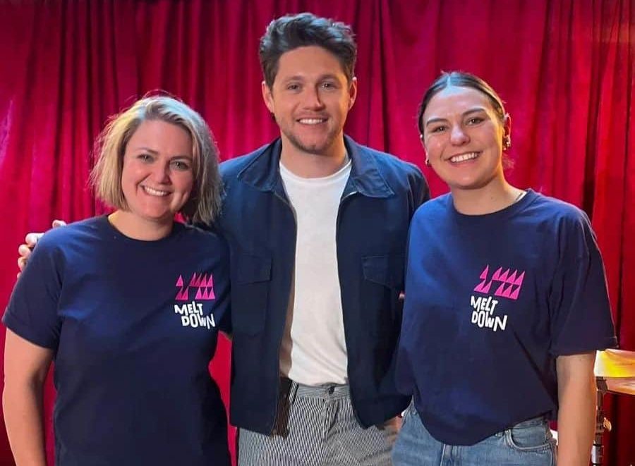 Two members of staff from Meltdown in Dublin pose with Naill Horan.