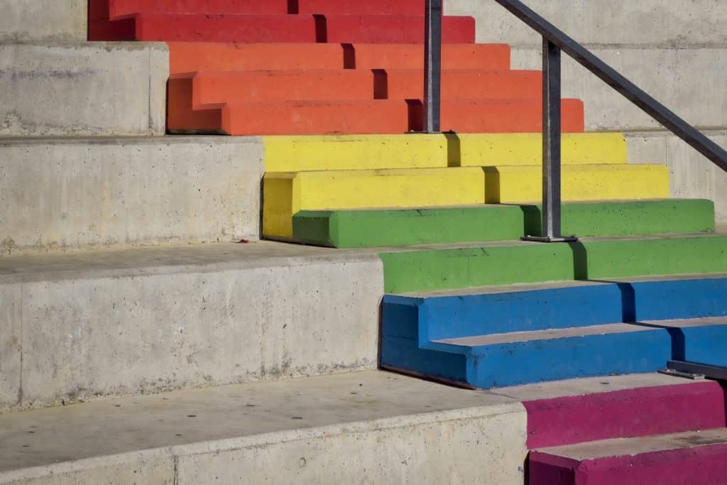Rainbow steps with a black handrail.