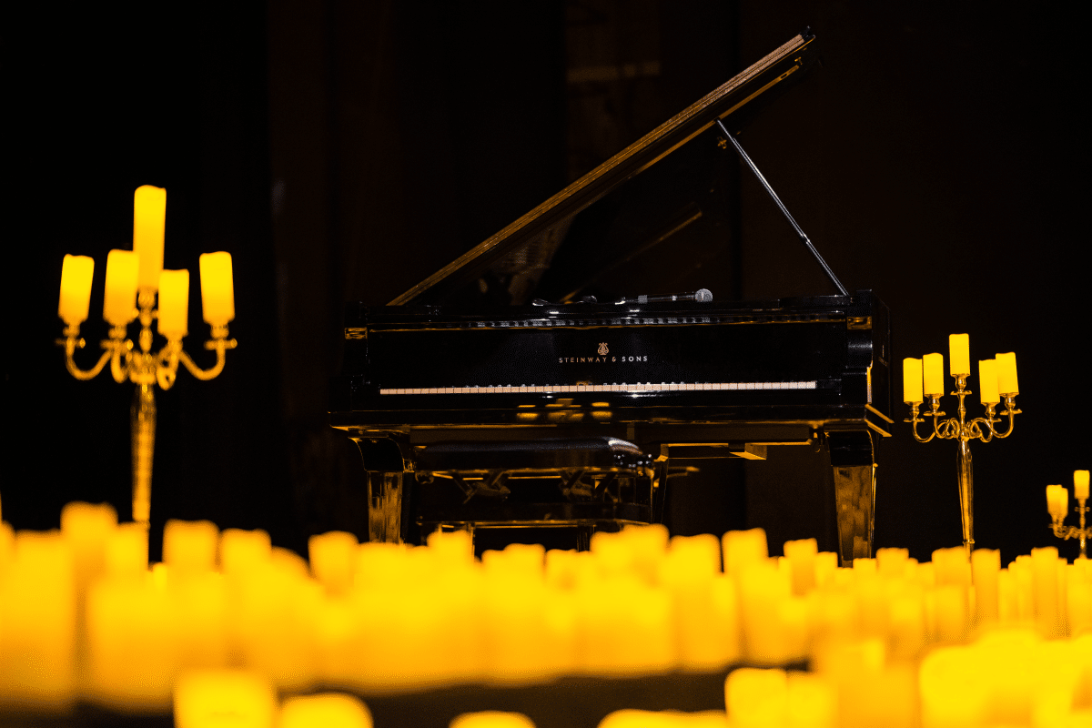 A grand piano amid hundreds of candles